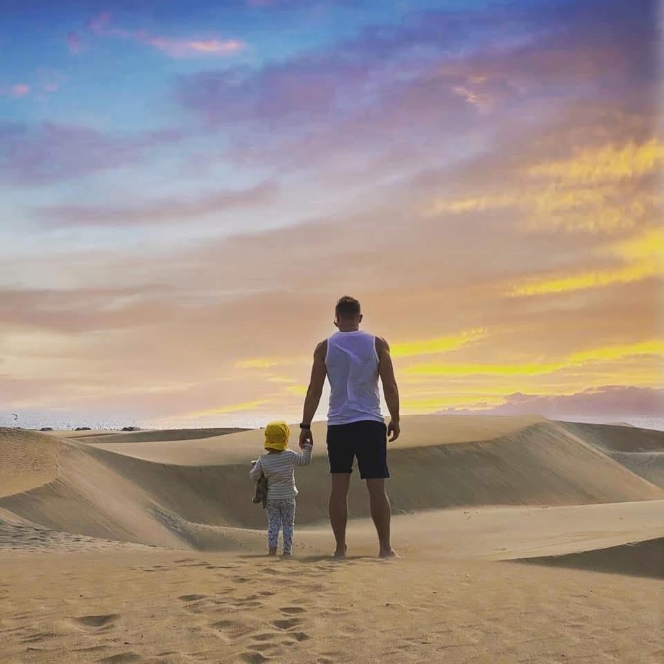 Behar walking the dunes with his child